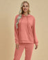 Woman wearing a pink hoodie and pants on a beige background