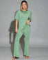 Woman wearing a green jumpsuit against a gray background