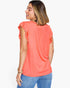 A woman shown from the back wearing a coral orange short-sleeve top with ruffled shoulder details and blue jeans, against a plain white background.