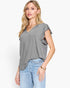 A woman modeling a heather gray short-sleeve top with ruffled trim on the sleeves and a V-neckline, paired with light blue jeans against a plain white studio background.