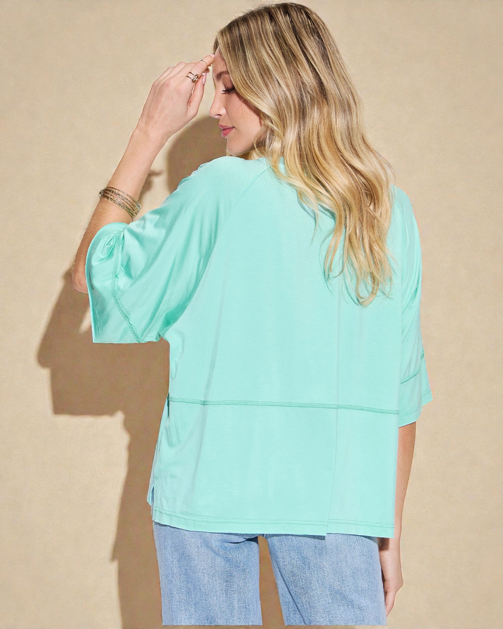 Woman wearing a light blue top against a beige background