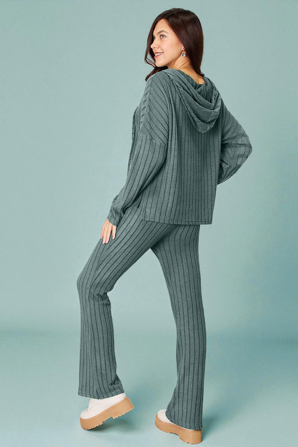 Woman wearing a ribbed knit outfit on a light blue background