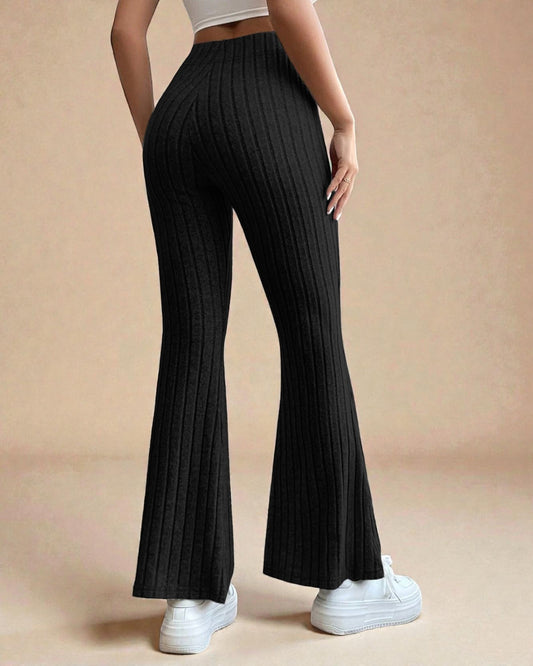 Black ribbed flared pants worn by a person on a beige background