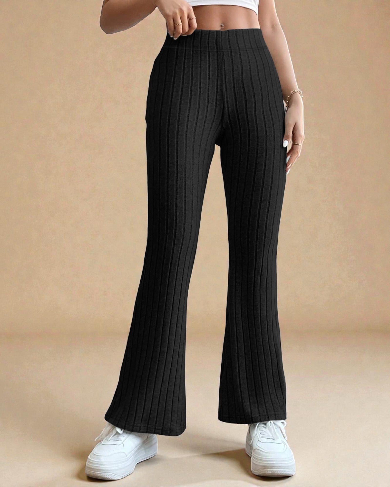 Black ribbed pants worn by a person on a beige background