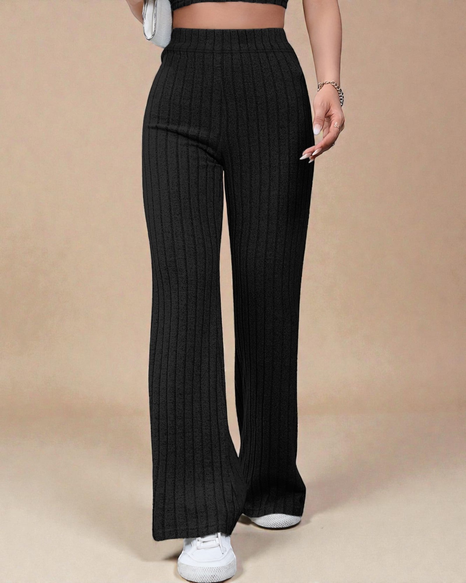 Person wearing black ribbed wide-leg pants on a beige background