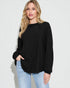 Woman wearing a black long-sleeve top and light blue jeans on a white background