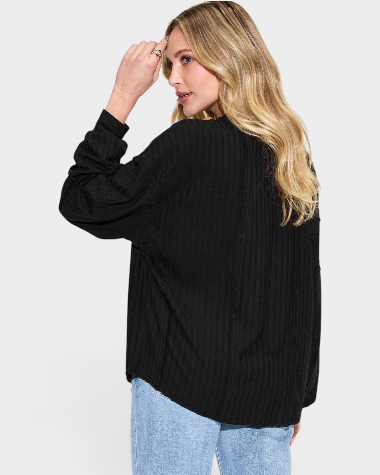Woman wearing a black jacket on a light gray background