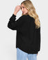 Woman wearing a black jacket on a light gray background