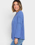 Woman wearing a blue ribbed sweater against a white background