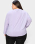 Person wearing a light purple ribbed sweater on a white background