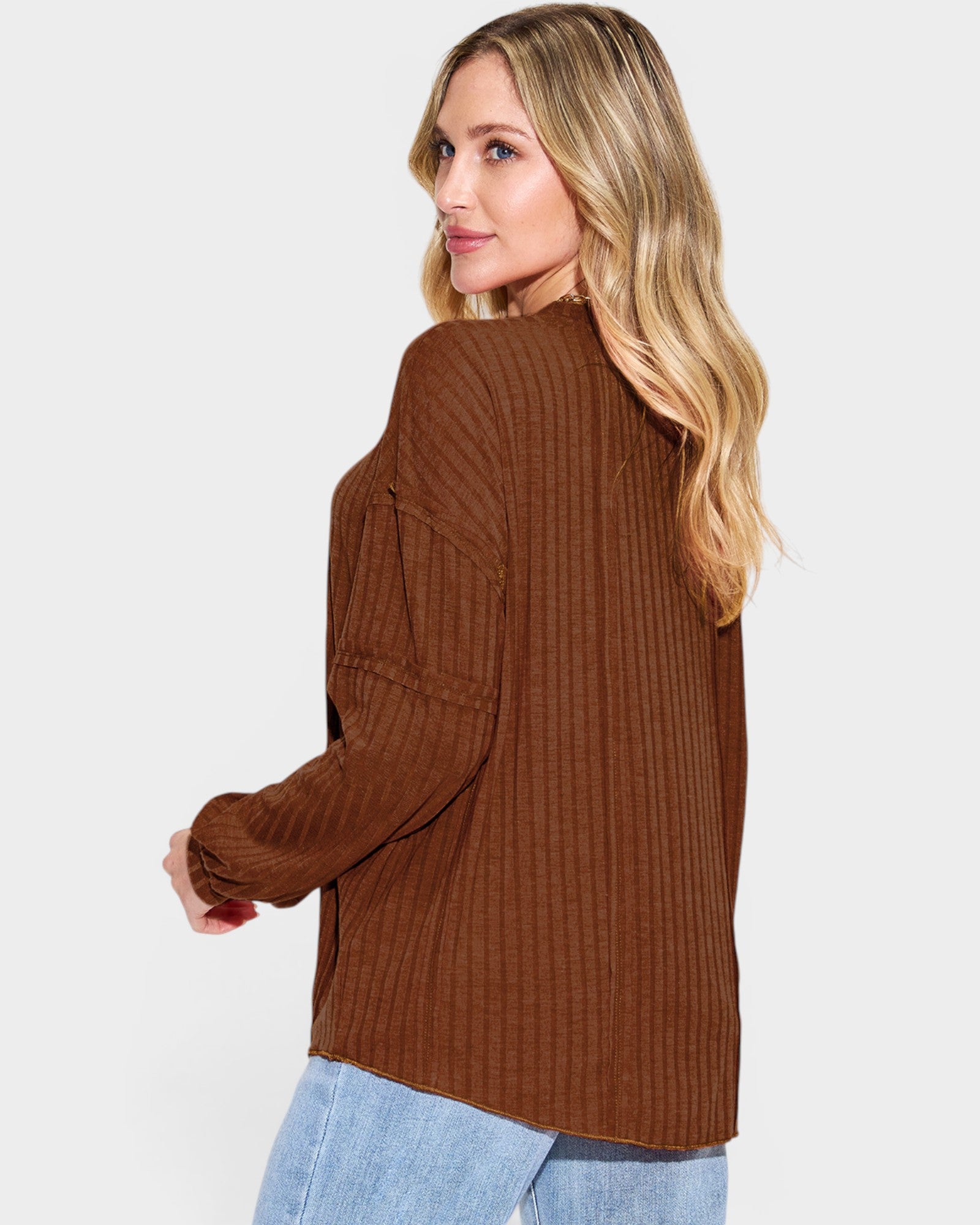 Woman wearing a brown ribbed sweater on a white background