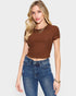 Woman wearing a brown ribbed crop top and blue jeans on a white background