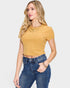 Woman wearing a yellow top and blue jeans on a light gray background