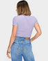Person wearing a purple ribbed crop top and blue jeans on a white background