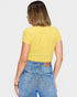Person wearing a yellow top and blue jeans on a plain background