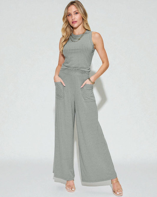 Woman wearing a gray ribbed jumpsuit on a white background