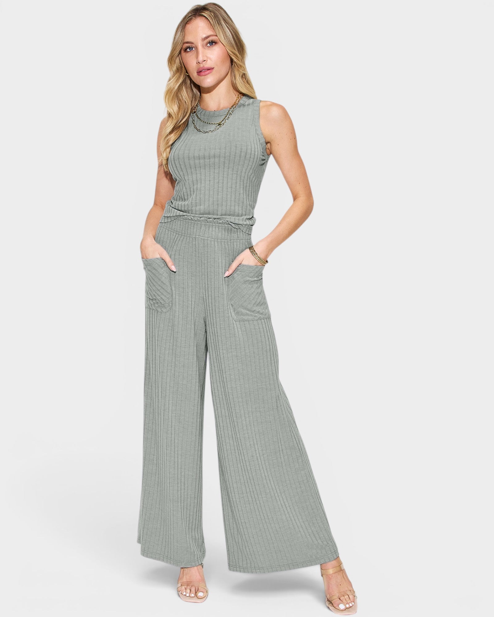 Woman wearing a green ribbed jumpsuit on a white background