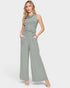 Woman wearing a green ribbed jumpsuit on a white background
