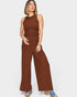 Woman wearing a brown ribbed jumpsuit on a white background