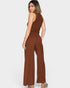 Woman wearing a brown ribbed jumpsuit on a white background