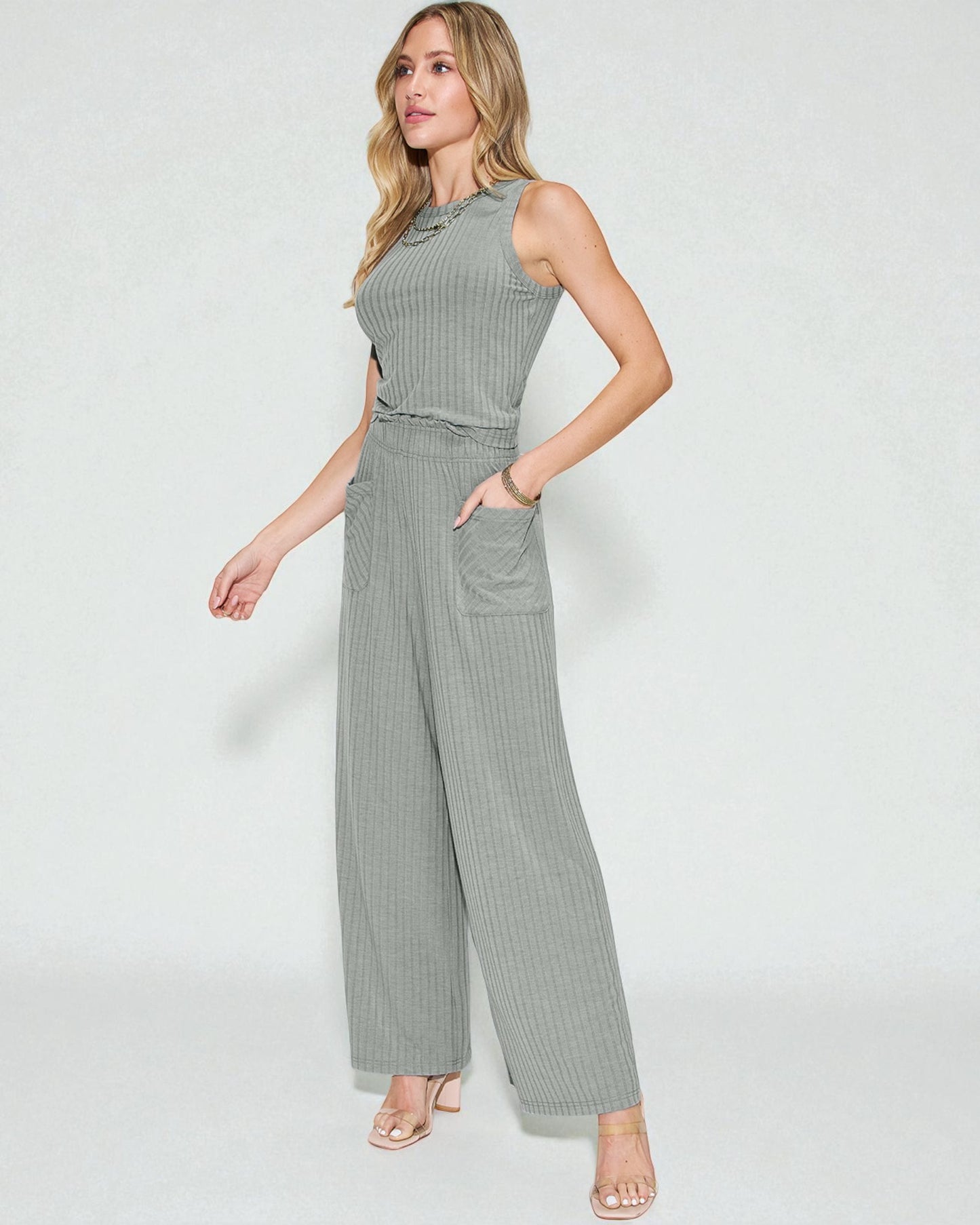 Woman wearing a gray ribbed jumpsuit on a white background