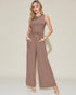 Woman wearing a brown ribbed jumpsuit on a beige background