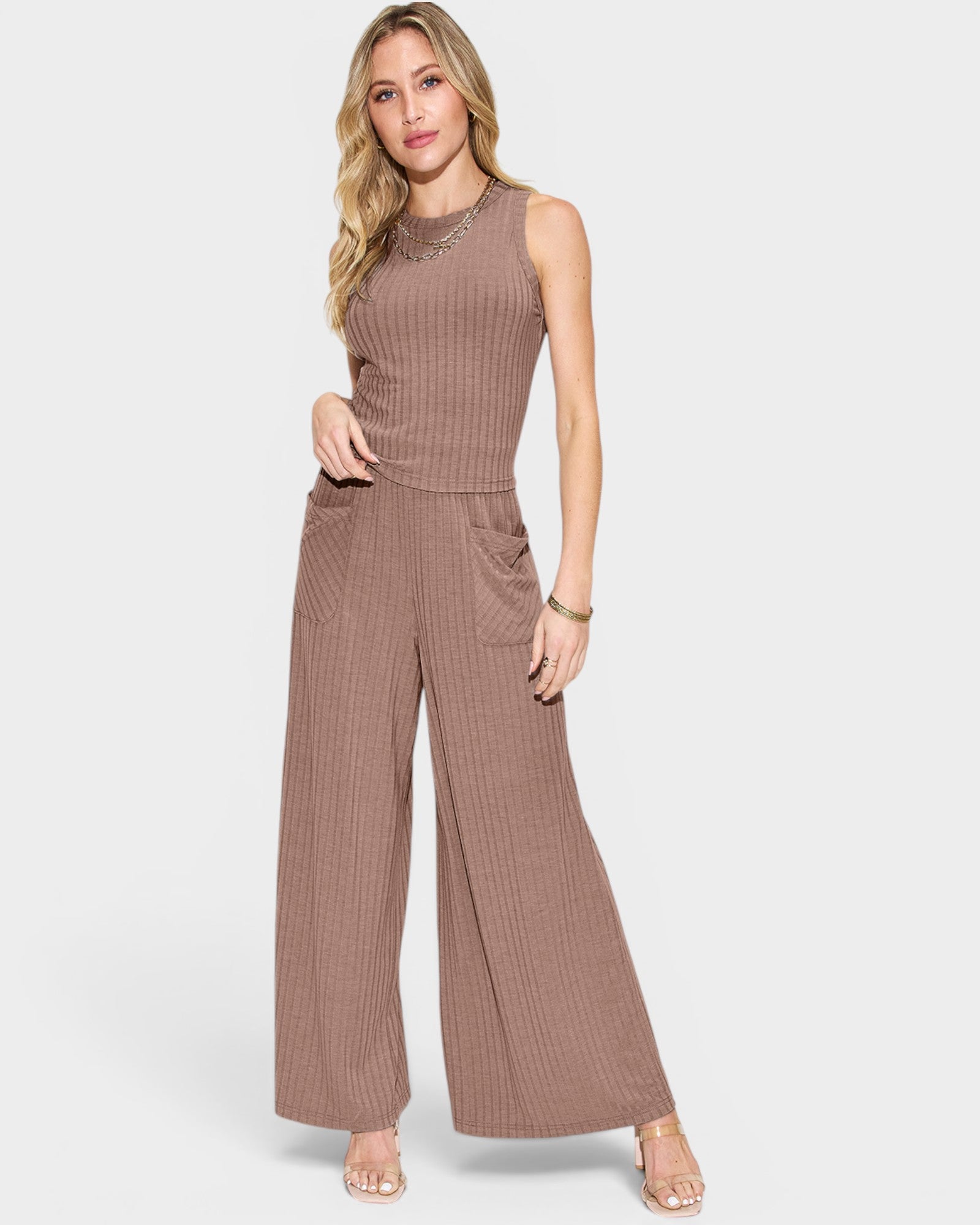 Woman wearing a brown ribbed jumpsuit on a white background
