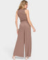 Woman wearing a brown ribbed jumpsuit on a white background