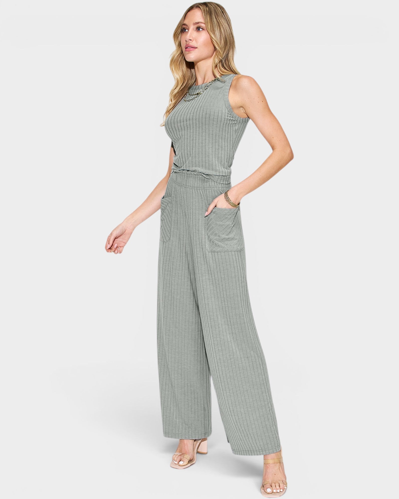 Woman wearing a green ribbed jumpsuit on a white background