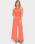 Woman wearing a coral jumpsuit on a white background