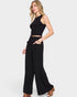Woman wearing a black sleeveless top and wide-leg pants on a white background