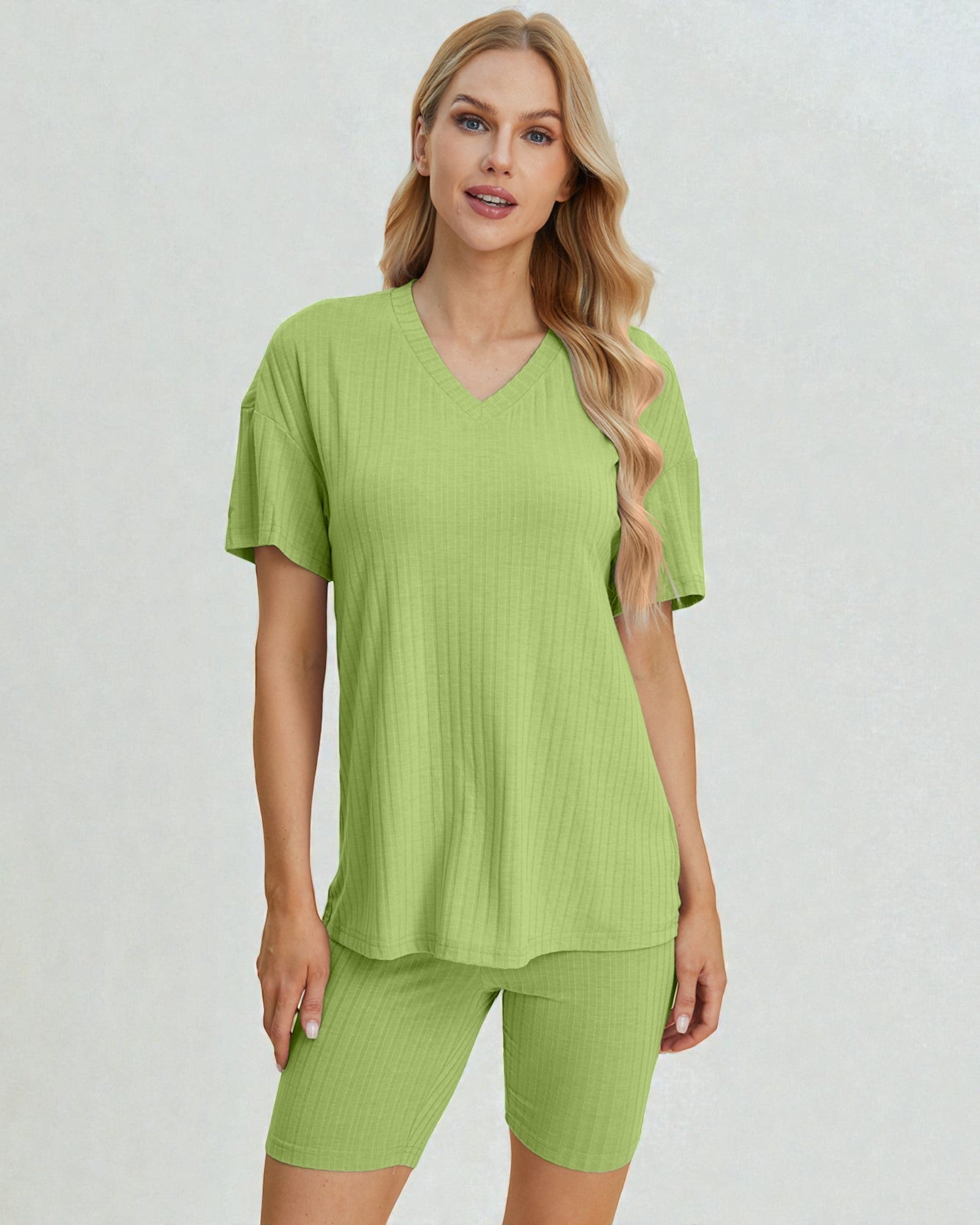 Woman wearing a green outfit on a plain background
