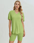 Woman wearing a green outfit on a plain background