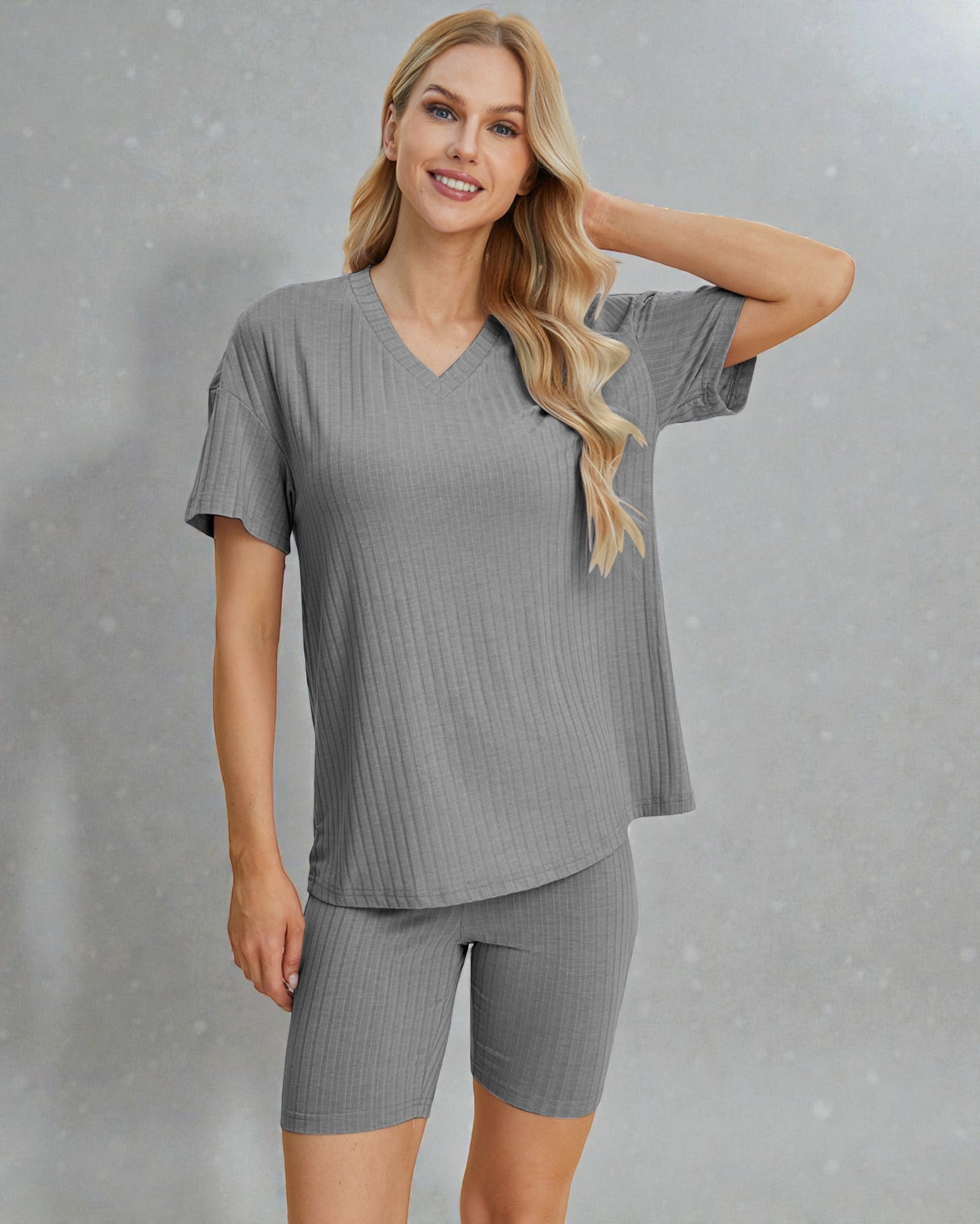 Woman wearing a gray ribbed outfit with a matching top and shorts on a gray background