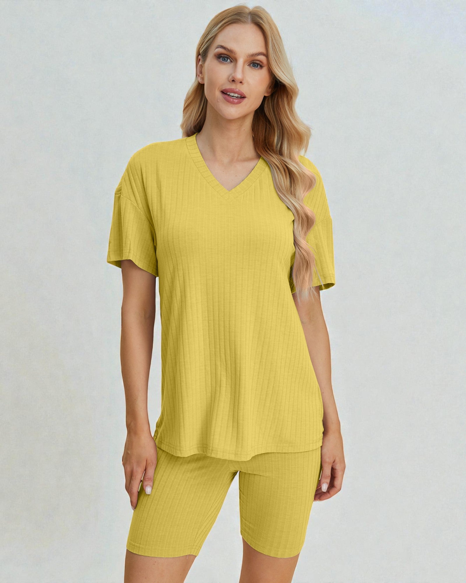 Woman wearing a yellow outfit on a plain background