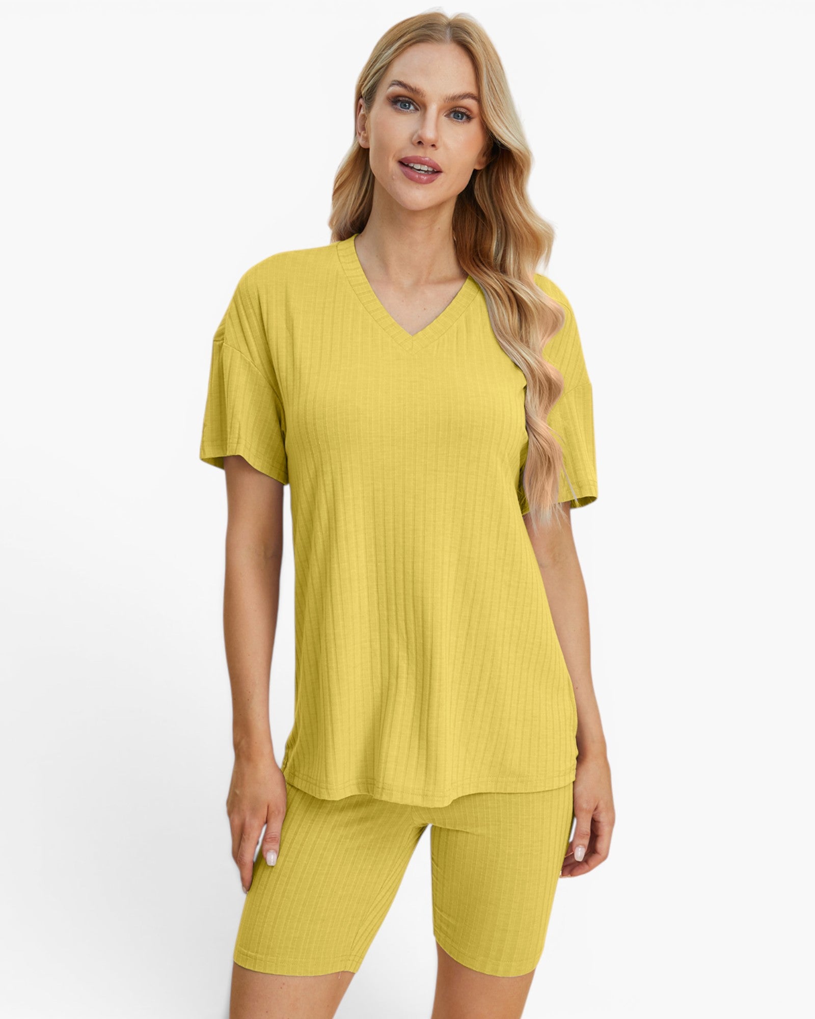 A woman modeling a matching two-piece ribbed lounge set in a bright yellow color, featuring a short-sleeve V-neck top and fitted biker shorts, against a plain white studio background.