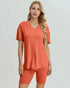 Woman wearing a coral-colored outfit on a plain background