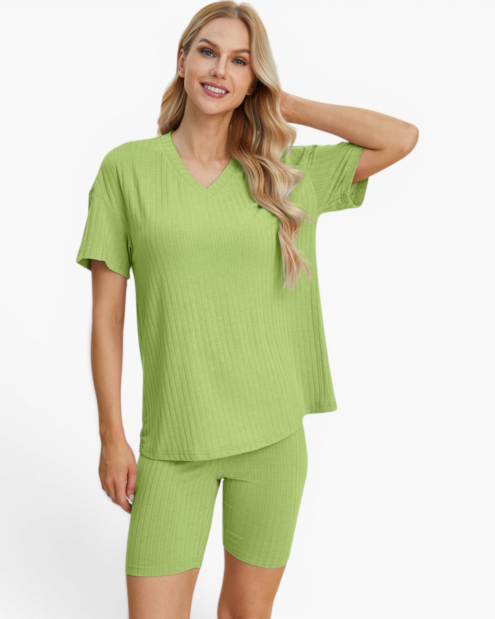 A woman modeling a matching ribbed two-piece loungewear set in light green, featuring a short-sleeve V-neck top and coordinating shorts, against a plain light gray studio background.