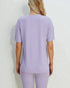 Person wearing a light purple ribbed t-shirt and pants on a white background