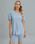 Woman wearing a light blue pajama set against a gray background