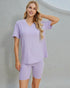 Woman wearing a light purple pajama set against a plain background