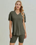 Woman wearing an olive green outfit with a plain background