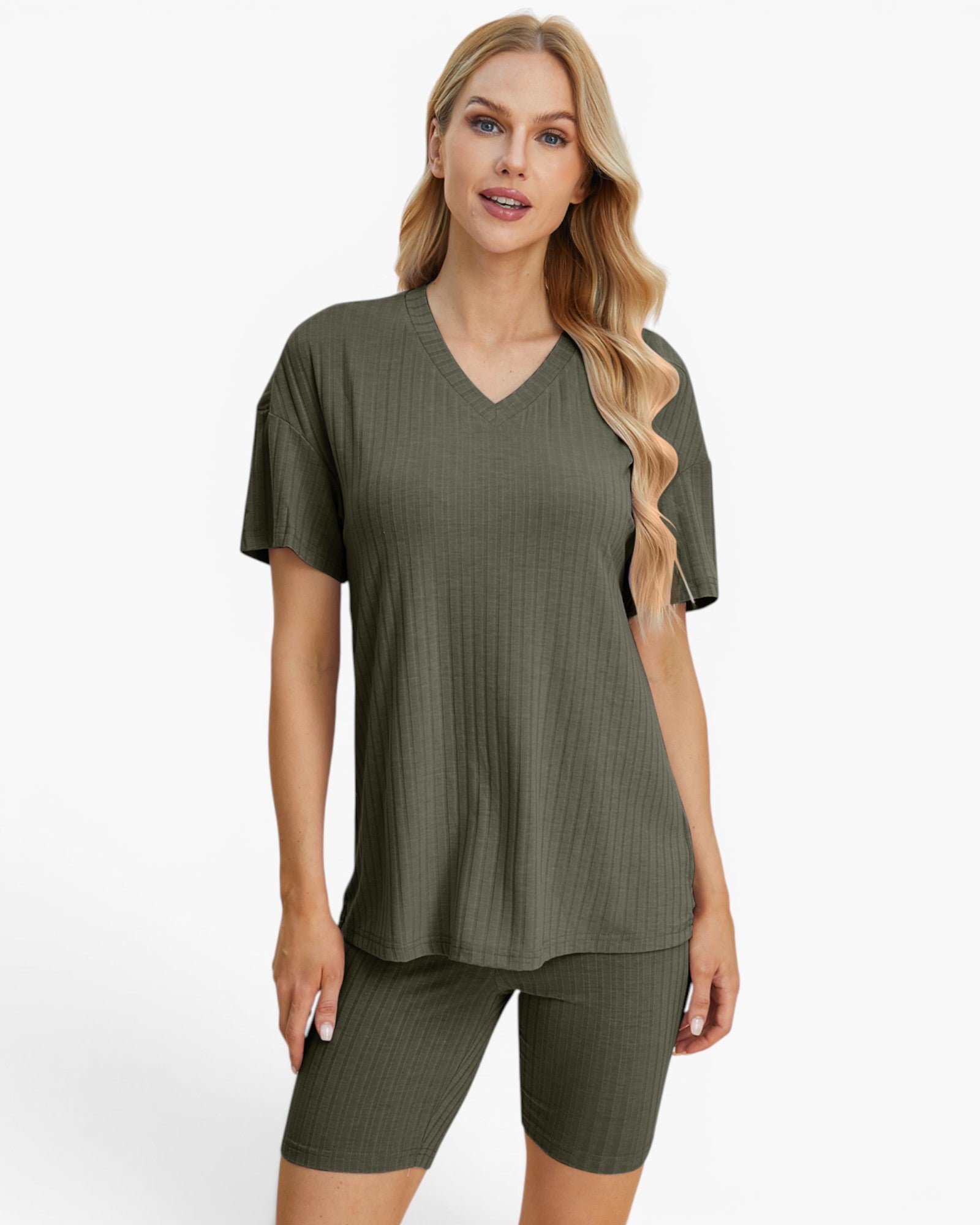 A woman modeling a matching ribbed two-piece lounge set in olive green, featuring a short-sleeve V-neck top and fitted biker shorts, against a plain white studio background.