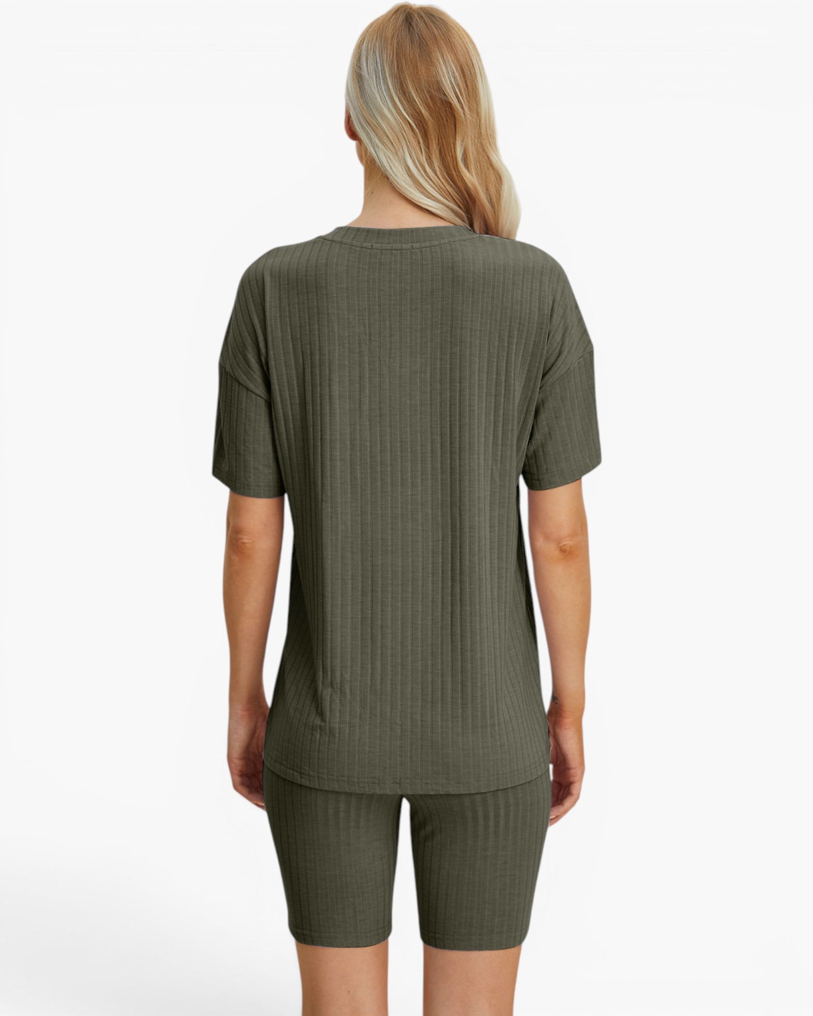 A woman viewed from the back wearing a ribbed short-sleeve top and matching ribbed biker shorts in an olive green color, set against a plain white studio background.