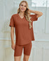 Woman wearing a brown ribbed pajama set in a bathroom setting