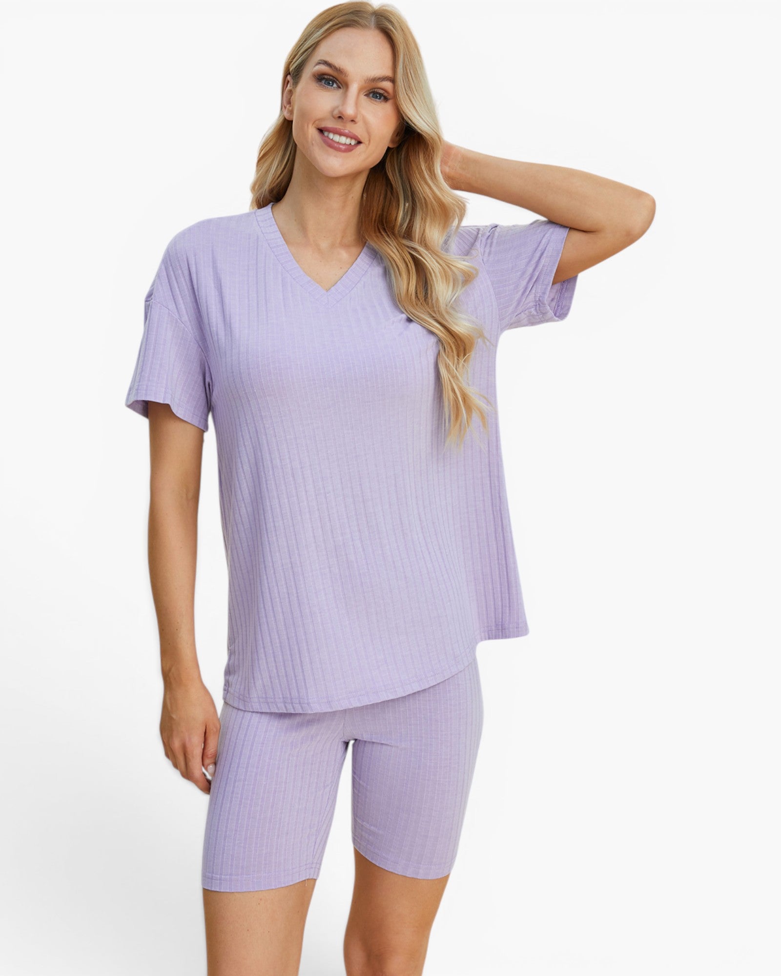 A woman modeling a light purple ribbed two-piece pajama set consisting of a short-sleeve V-neck top and matching fitted shorts, against a plain white studio background.