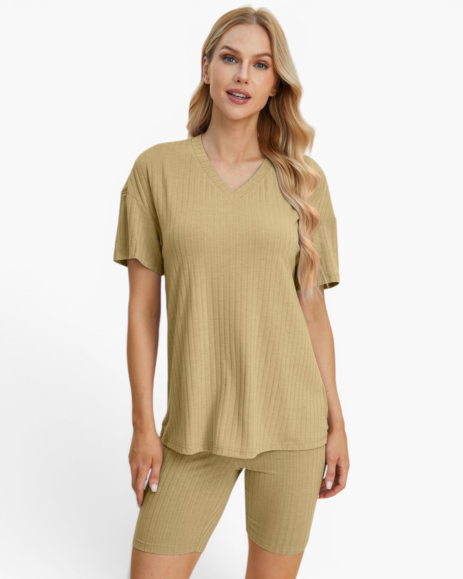 A woman modeling a matching two-piece lounge set consisting of a short-sleeve V-neck ribbed top and matching ribbed biker shorts in a light khaki color, set against a plain white background.