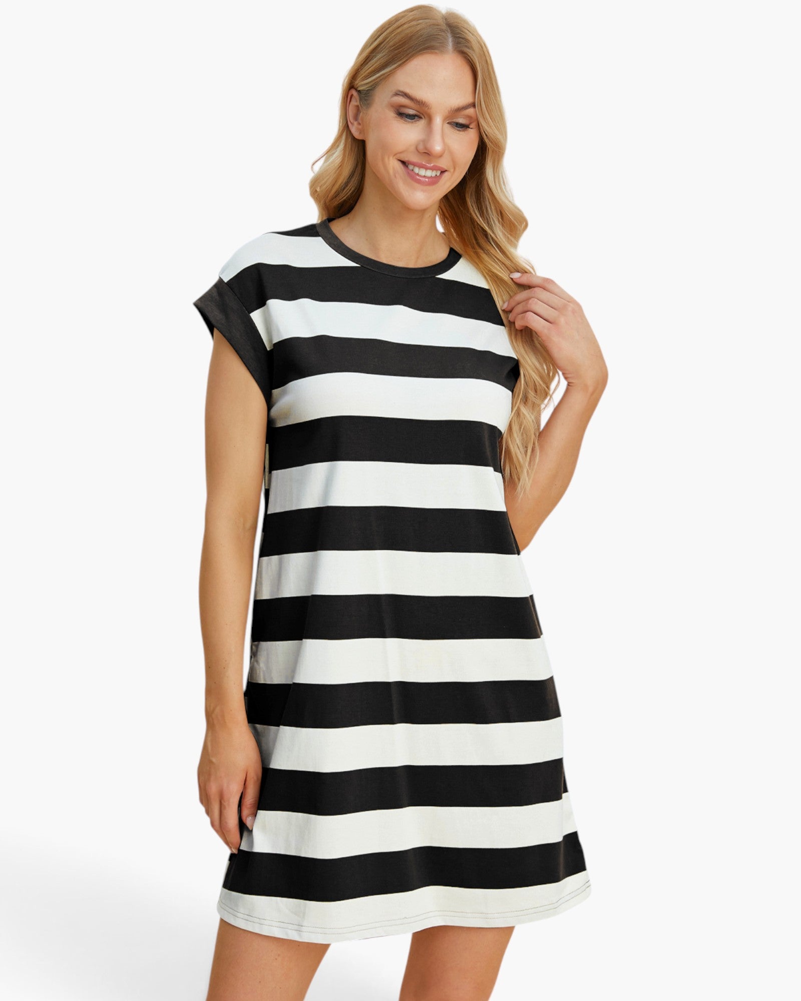 A woman wearing a short-sleeve black and white horizontally striped t-shirt dress, posing against a clean white studio background.