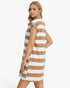 A woman modeling a sleeveless, A-line shift dress with horizontal tan and white stripes, photographed against a clean white studio background.