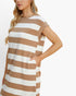 A woman wearing a loose, short-sleeve dress with horizontal brown and off-white stripes, shown from the side against a plain white background.